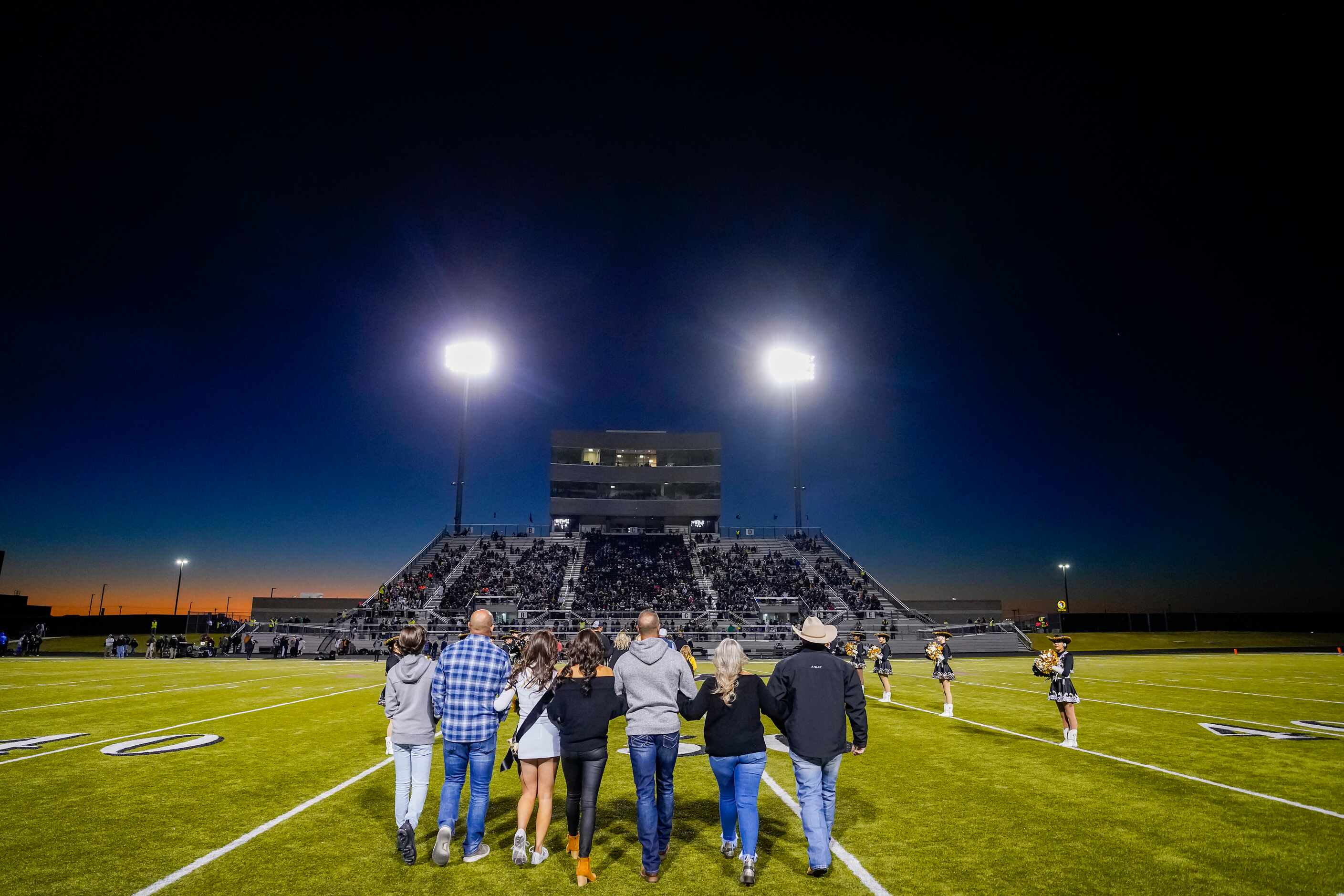 Royse City family members accompany a cheerleader during senior day festivities before a...