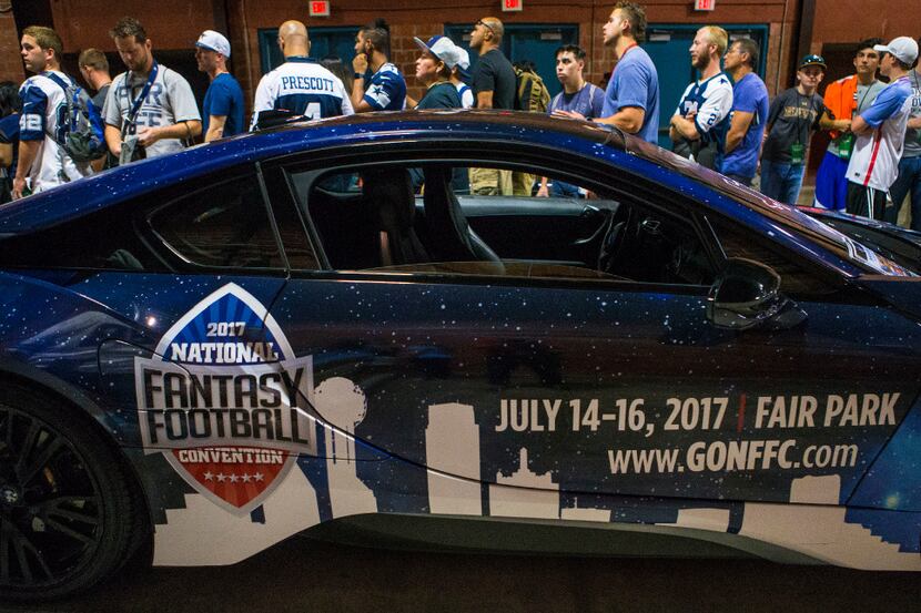 Fans wait in line for autographs alongside a National Fantasy Football Convention car during...