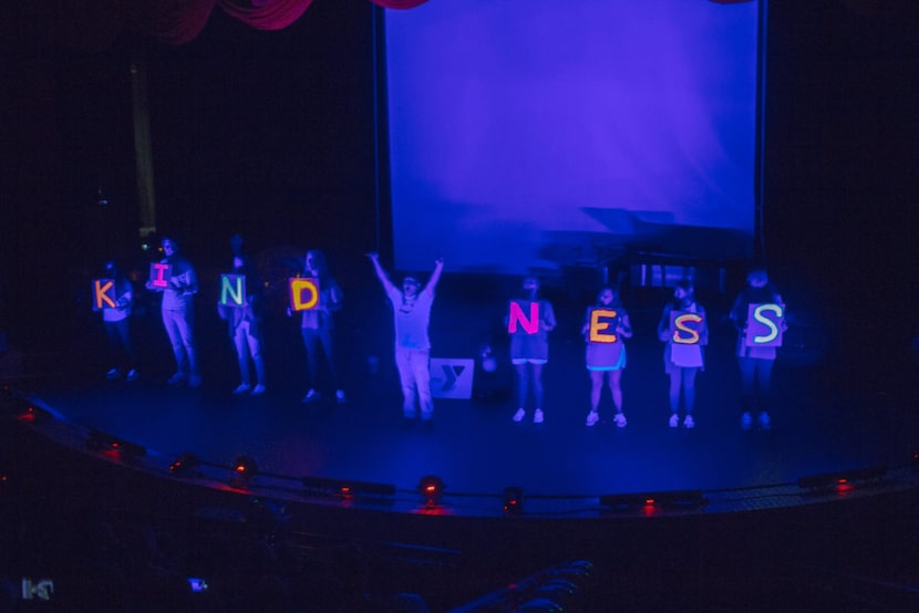 kindness spelled out in black light by kids and The Wezmore Project