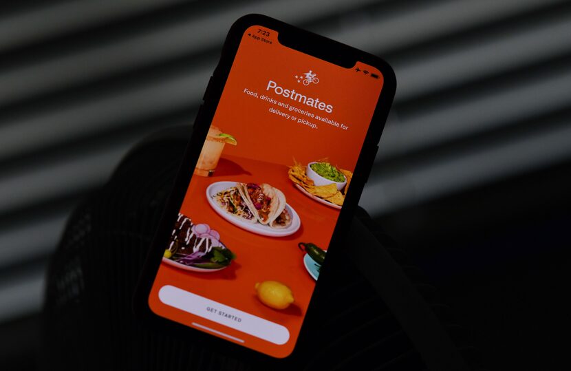 This photo taken on June 30 shows the delivery app Postmates on a smartphone screen in Los...