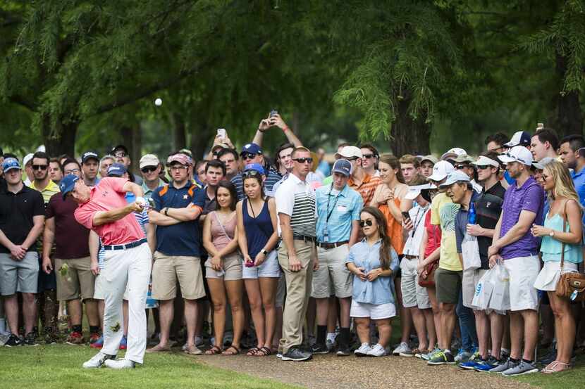 The gallery makes way for Jordan Spieth as he hits from the cart well off the fairway on the...