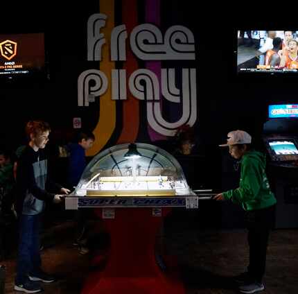 Zackery Verner (9) and Oliver Bench (10) play bubble hockey at Free Play in Arlington.