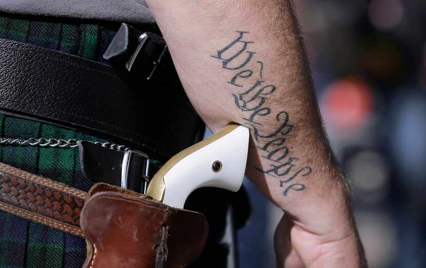 A man wears a pistol as he prepares for a rally in support of open carry gun laws at the...