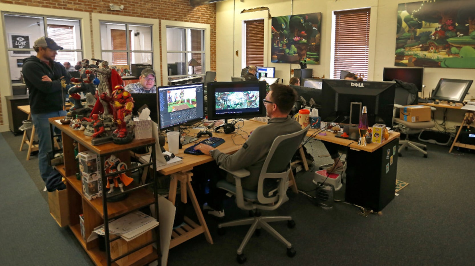 Employees of Playful Corp. are surrounded by action figures at work.