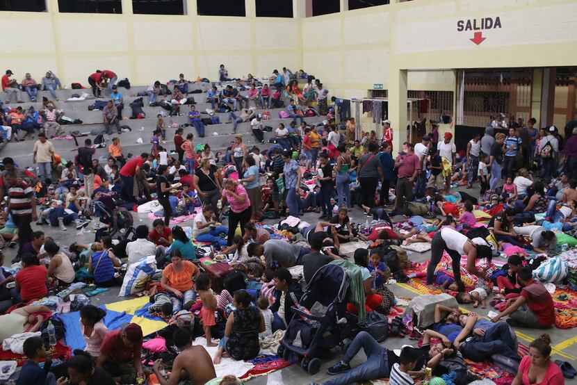 Immigrants, part of the Honduras  migrant caravan of more than 1,500 people, rest for the...