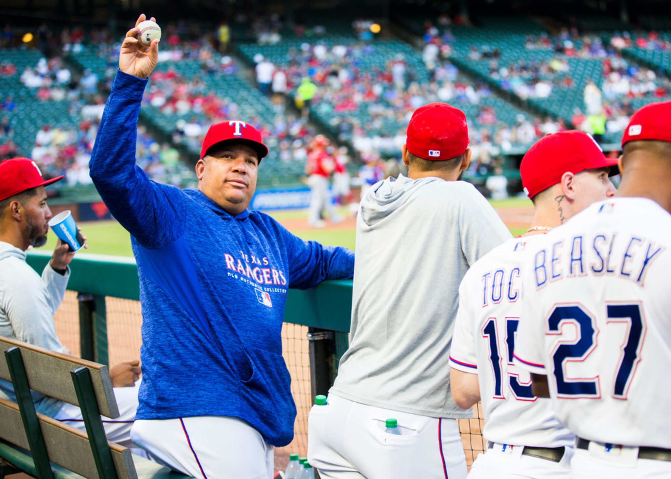 Texas Rangers starting pitcher Bartolo Colon throws a ball to a fan from the dugout during...