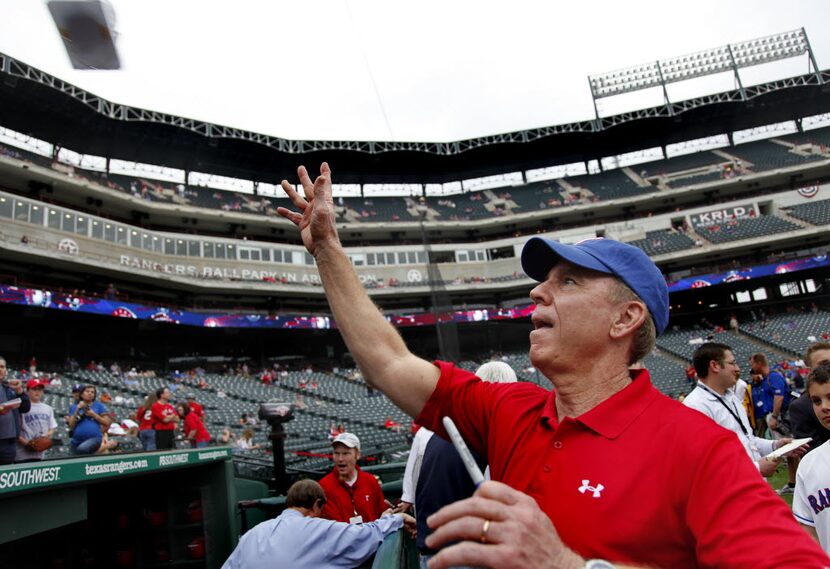 Hall of Fame Dallas Cowboys quarterback Roger Staubach throws an autographed souvenir back...