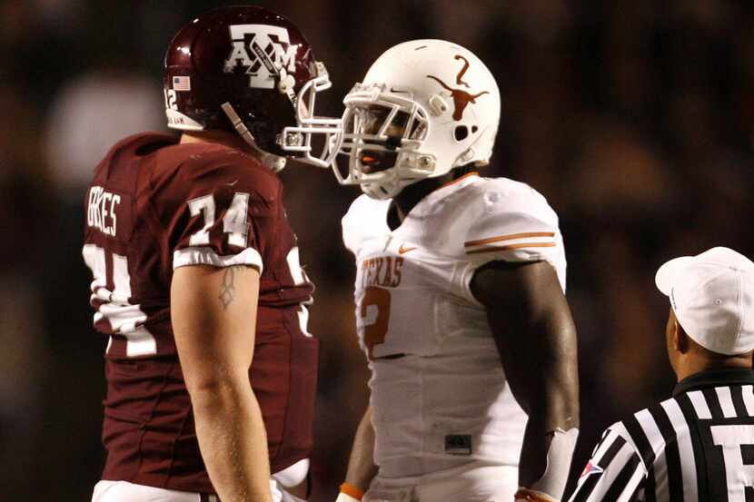 Right tackle Lee Grimes #74 of the Texas A&M Aggies confronts defensive end Sergio Kindle #2...