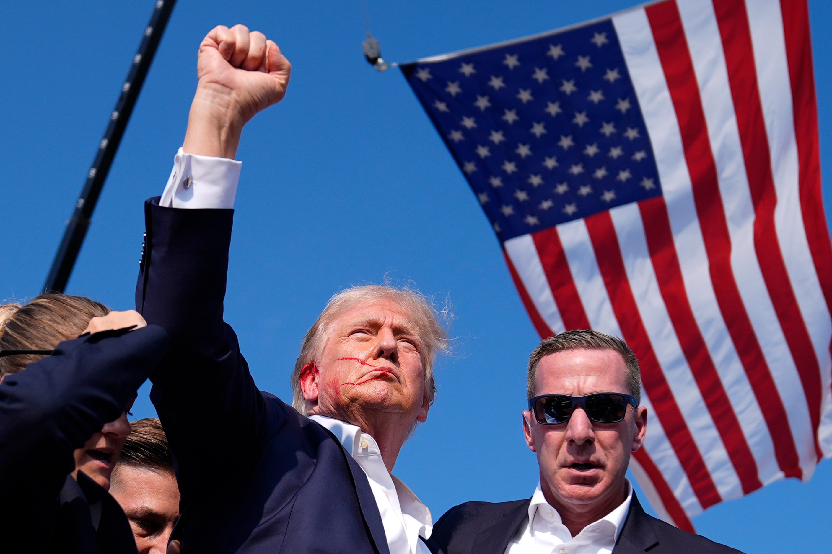 Republican presidential candidate former President Donald Trump reacts as he is surrounded...