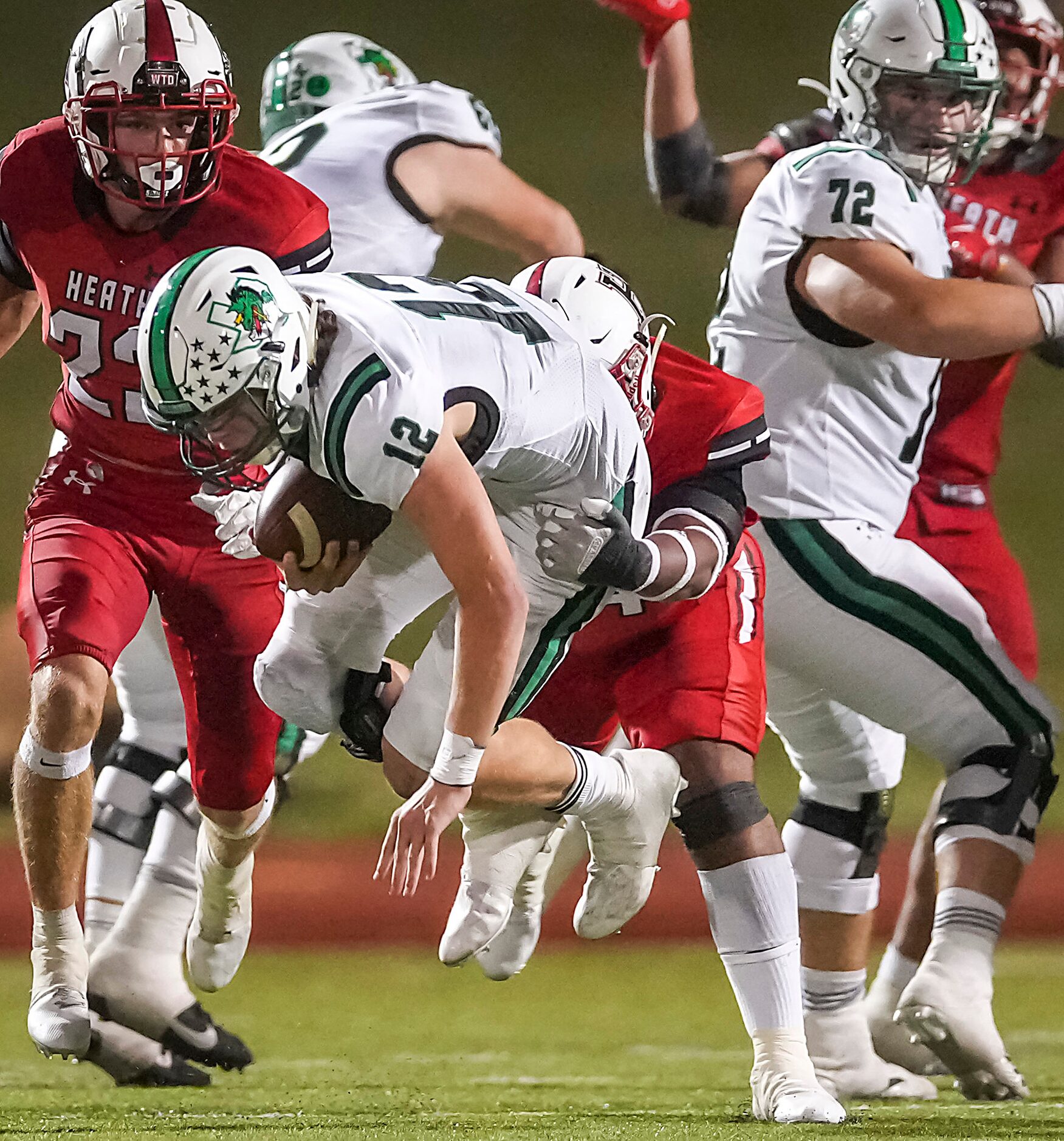 Southlake Carroll quarterback Kaden Anderson (12) is brought down by Rockwall-Heath’s Bryce...