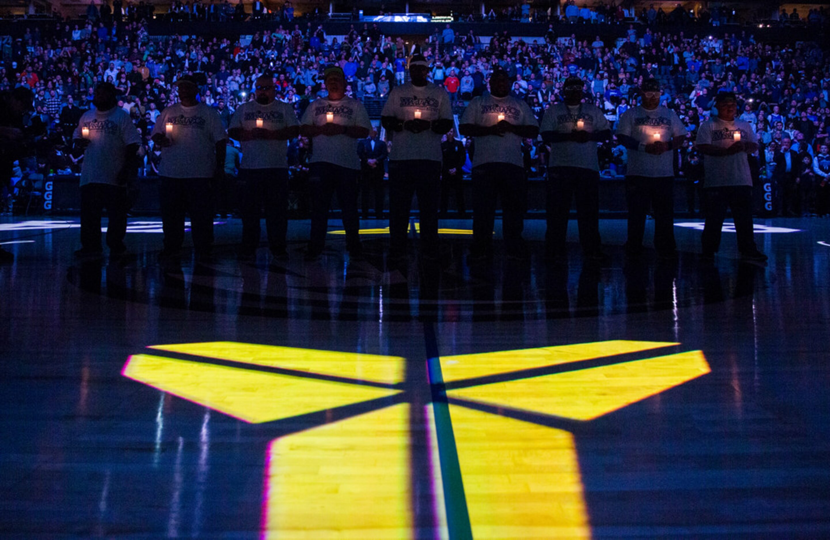 Mavs Maniacs hold candles during a tribute to former Los Angeles Laker Kobe Bryant and his...