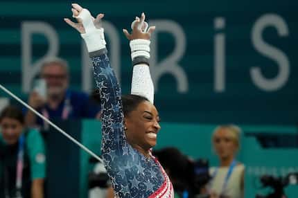 Simone Biles of the United States celebrates after competing on the uneven bars during the...
