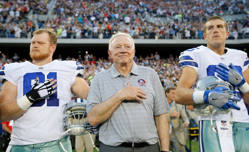 Dallas Cowboys owner and general manager Jerry Jones stands with players during the singing...