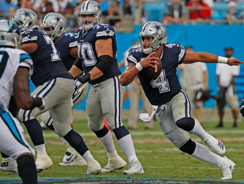 Dallas Cowboys offensive guard Zack Martin (70) watches as quarterback Dak Prescott (4)...