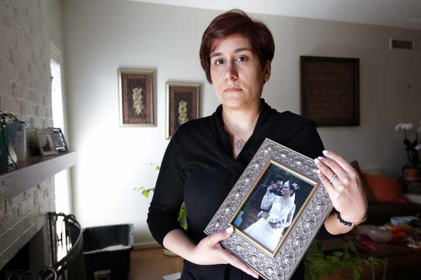 Navaz Ebrahim poses with a photograph of her sister and brother-in-law, at her home in...