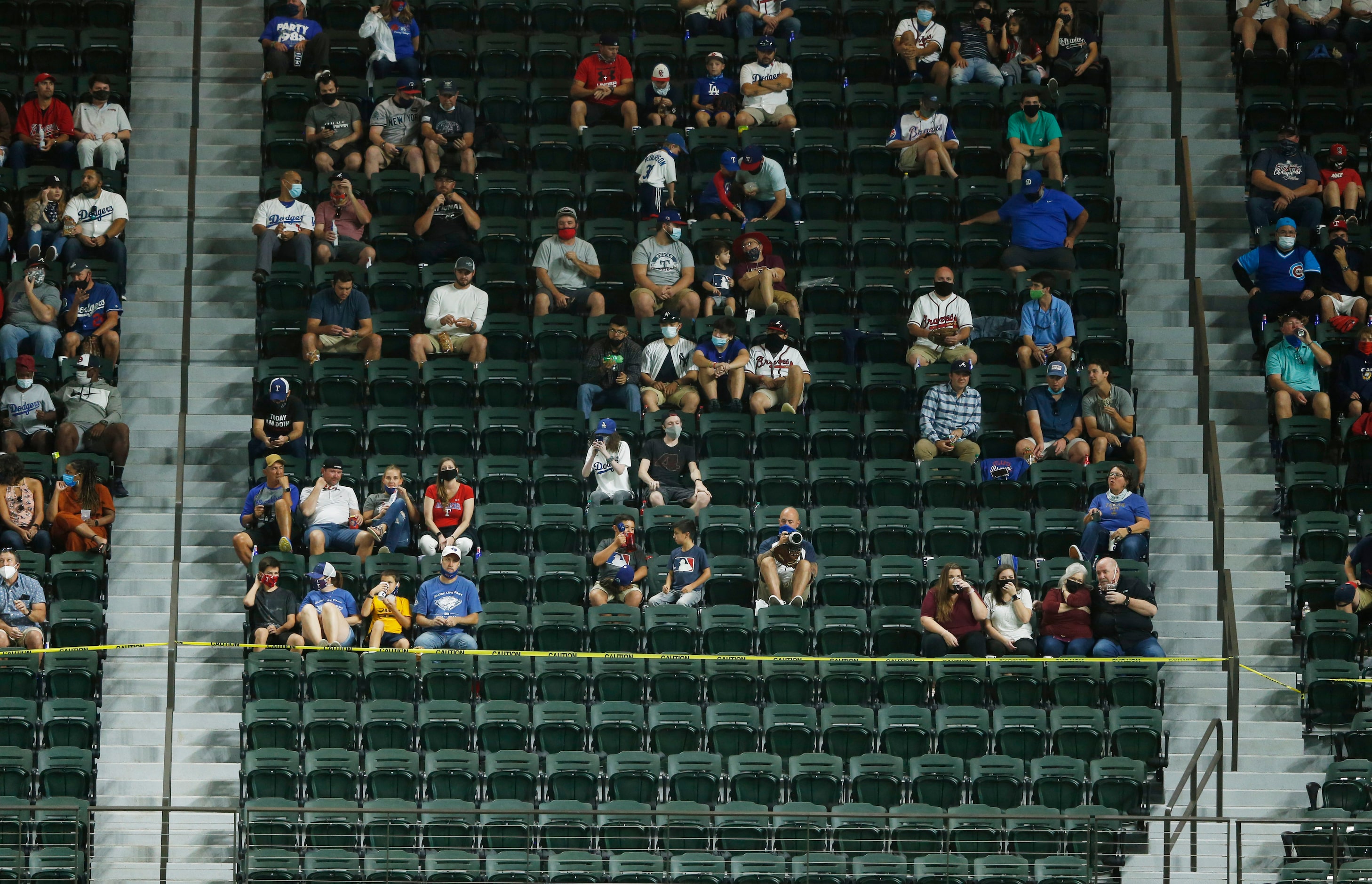 Baseball fans sit socially distanced during the third inning of game one between the Los...