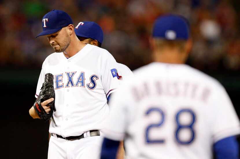 Texas Rangers starting pitcher Matt Harrison (54) waits as Texas Rangers manager Jeff...