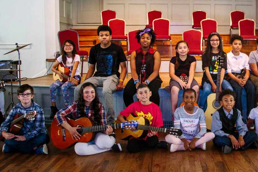 Jessica Garland (back row, second from right) teaches guitar to kids. 