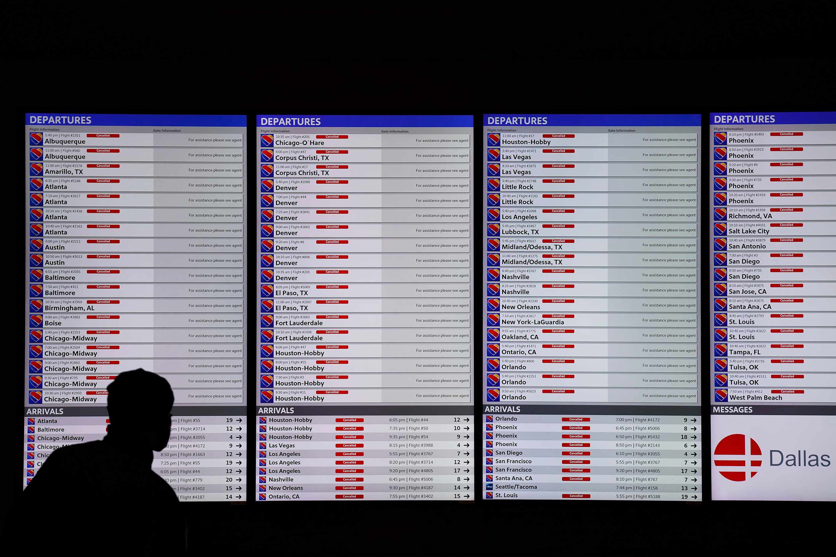 Flight status boards show all flights cancelled at Dallas Love Field as a winter storm...