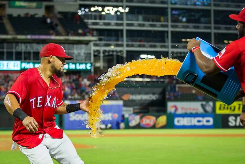 Texas Rangers second baseman Rougned Odor tries to elude a bucket of sport drink tossed on...