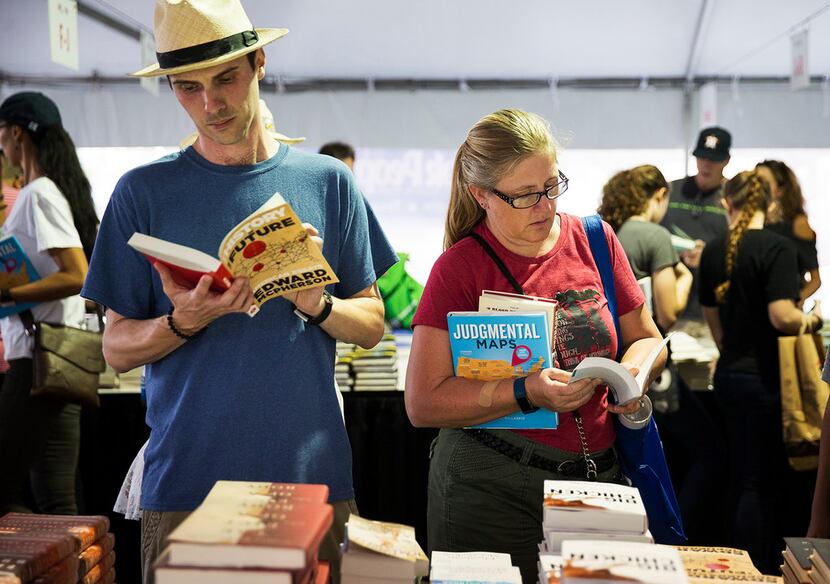 Ryland Trahan and Melissa McFarlin examine books inside a sales tent during the Texas Book...