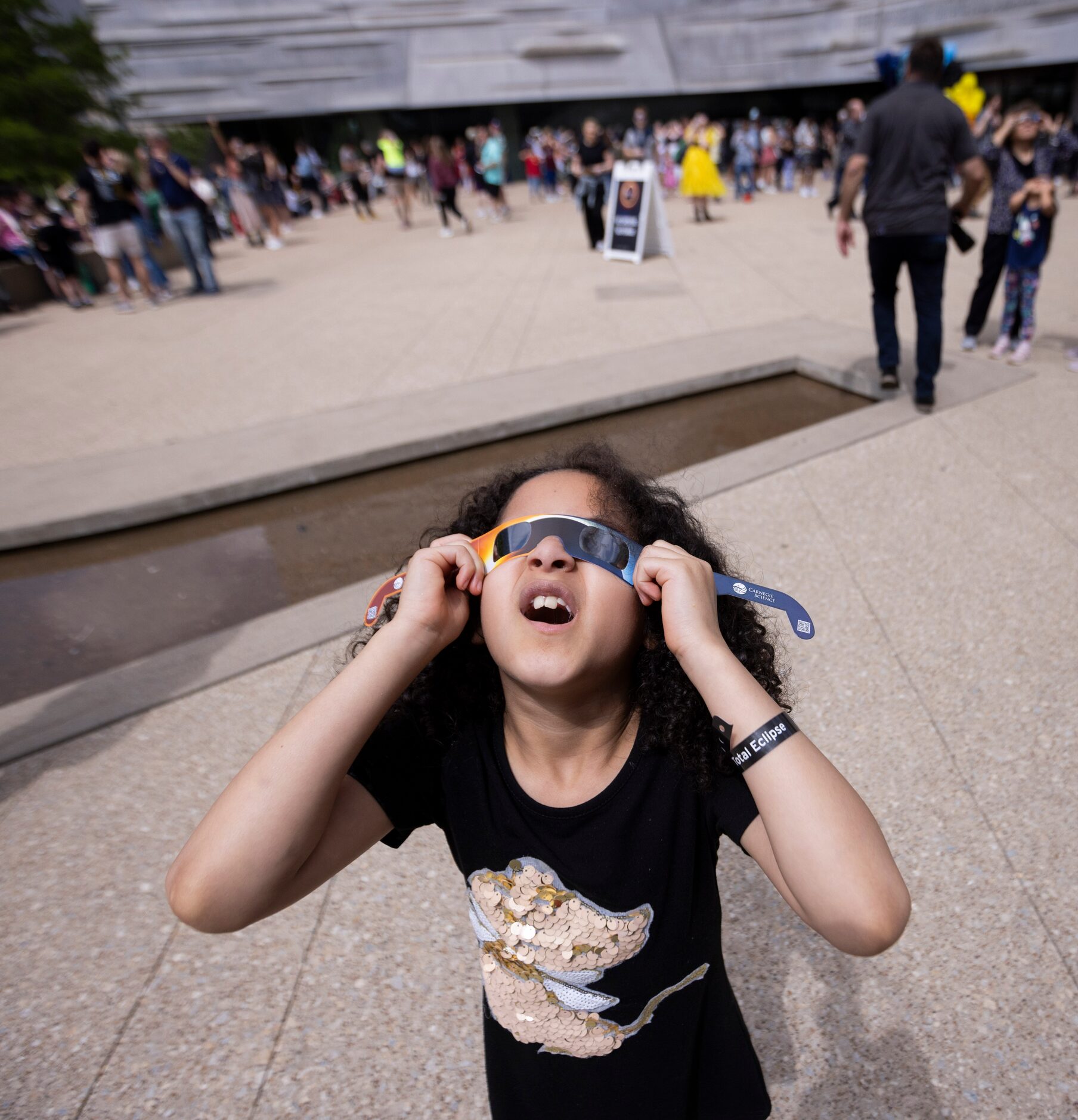 Autumn Williams, 8, of Euless looks up at the eclipse during the Great North American...