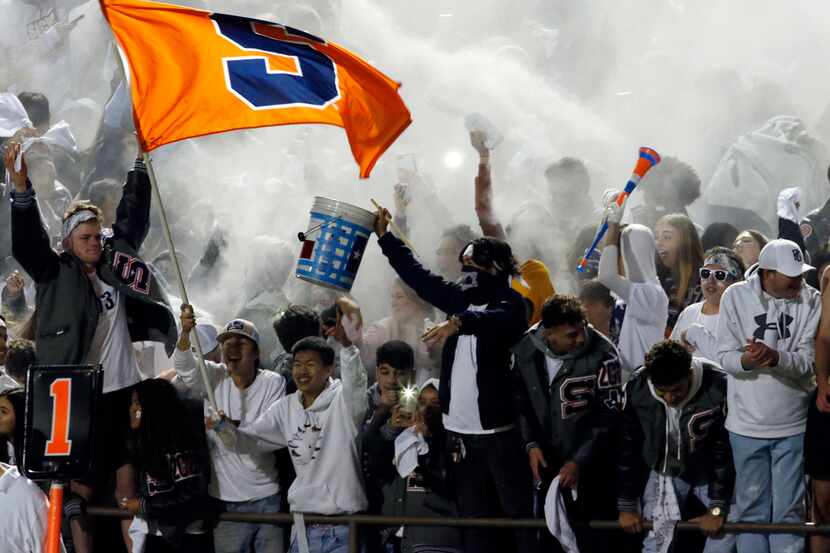 Sachse fans celebrate in a cloud of baby powder in the stands near the end of the team's...