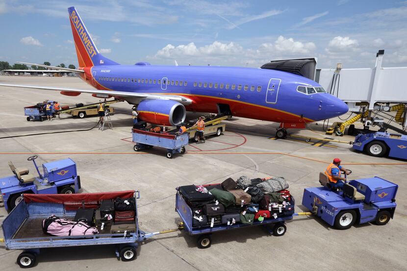 Baggage carts were towed to a Southwest Airlines jet at Bill and Hillary Clinton National...