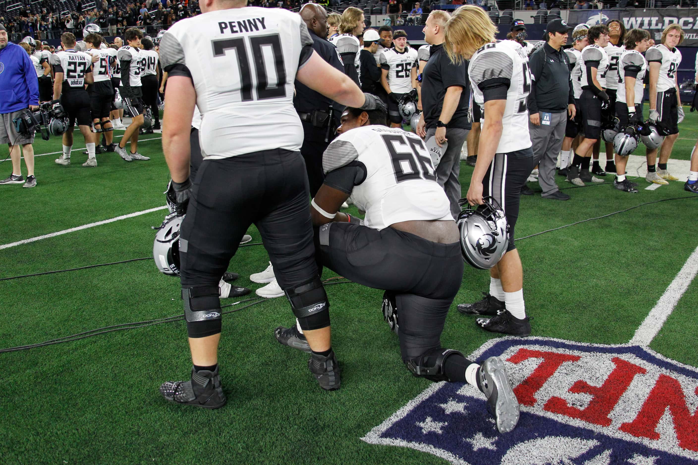 Denton Guyer's Nathan Penny (70) attempts to console teammate Willie Woodacre (66) following...