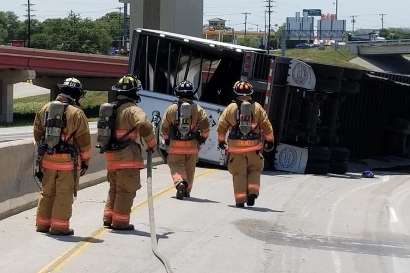 Irving firefighters inspect an overturned tractor-trailer 