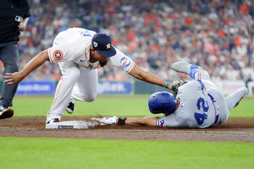 Houston Astros first baseman Jose Abreu, left, attempts the tag on Texas Rangers' Leody...