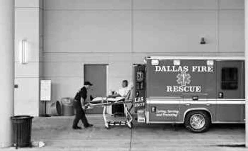  Dallas Fire-Rescue paramedics bring a patient to the ER at Baylor University Medical...