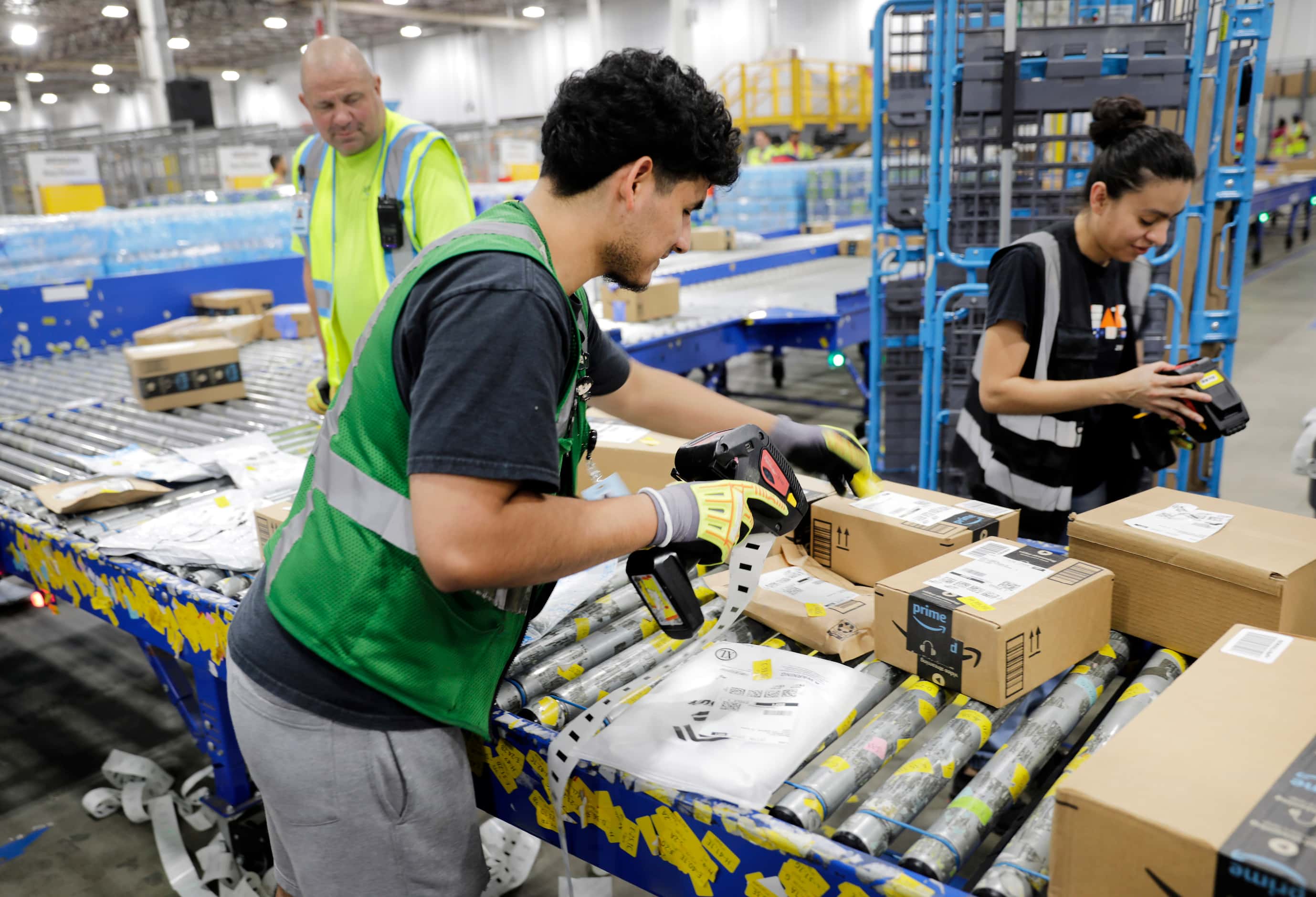 Crew members tag early PRIME day deal packages as they arrive at one of the country’s...