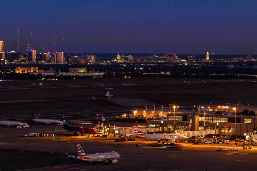 A nighttime view of Austin-Bergstrom International Airport with the city of Austin in the...