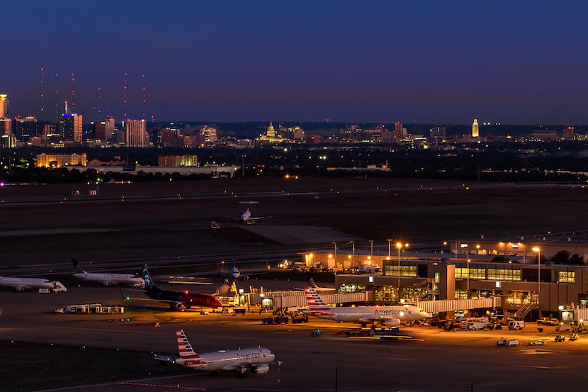 A nighttime view of Austin-Bergstrom International Airport with the city of Austin in the...