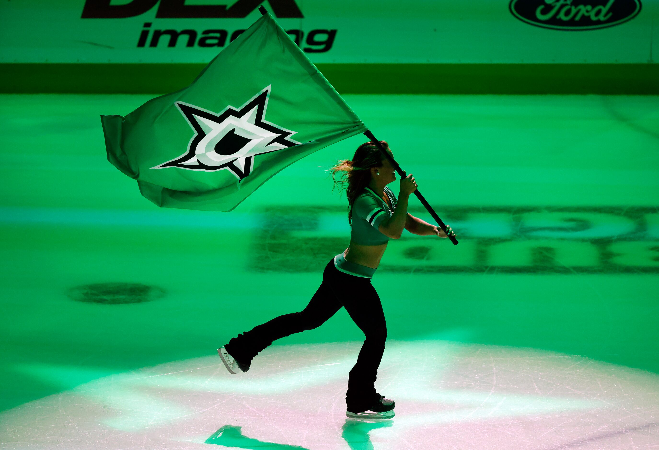 A Dallas Stars Ice Girl circled the ice with a team flag following their win over the...