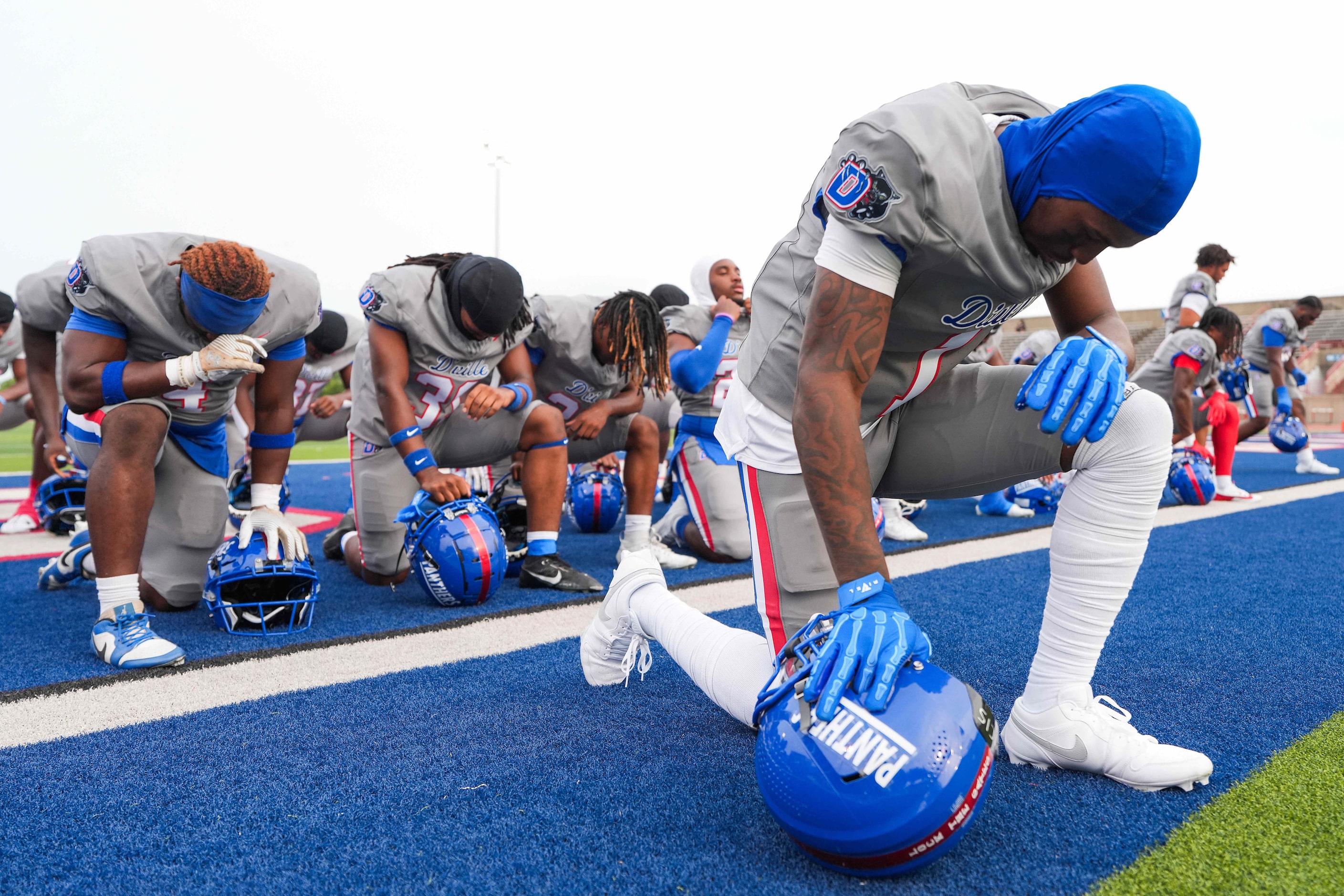 Duncanville wide receiver Dakorien Moore kneels in prayer before a high school football game...