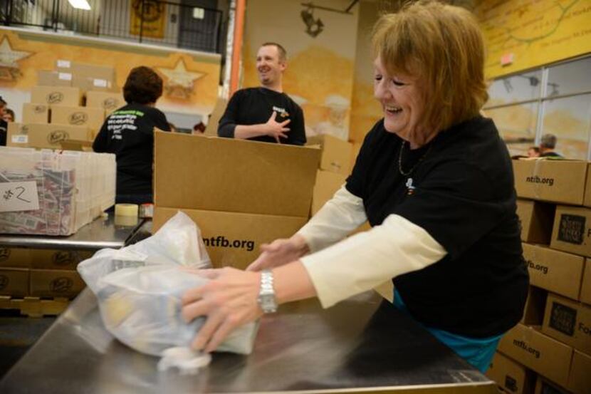 
Susan Trussell, a volunteers from Saville, Dodgen and Co., helps pack meals for the Food 4...