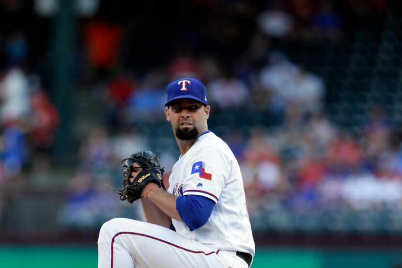 Texas Rangers' Dillon Gee throws to the New York Mets in the first inning of interleague...