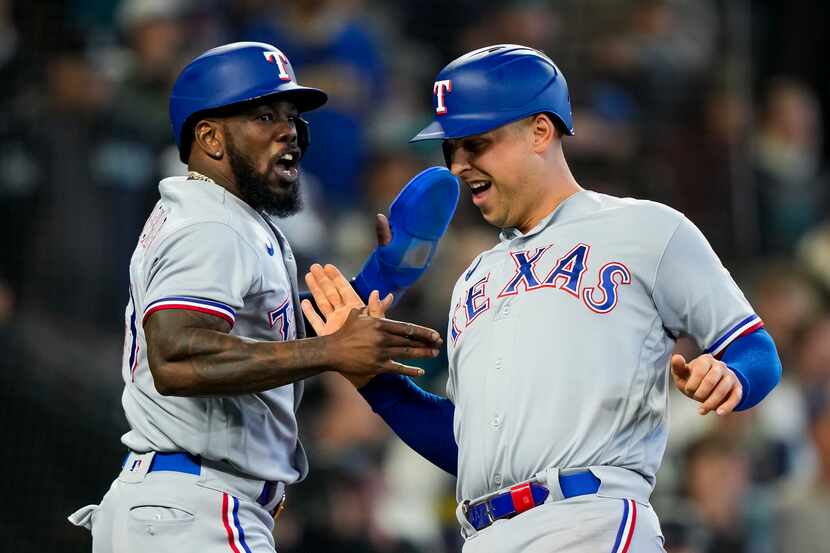 Texas Rangers' Adolis García, left, greets Nathaniel Lowe as they score on a two-run double...