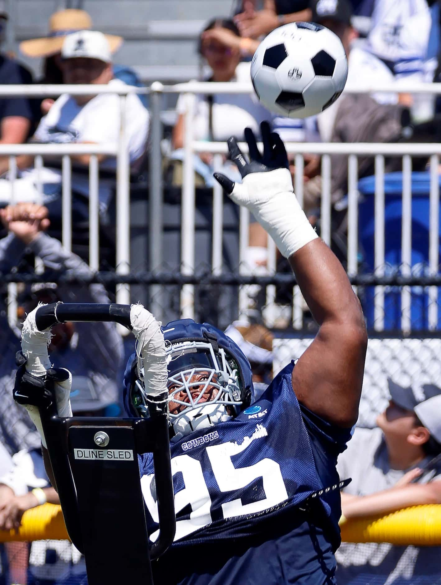 Dallas Cowboys defensive tackle Denzel Daxon (95) reaches to bat a thrown soccer ball during...