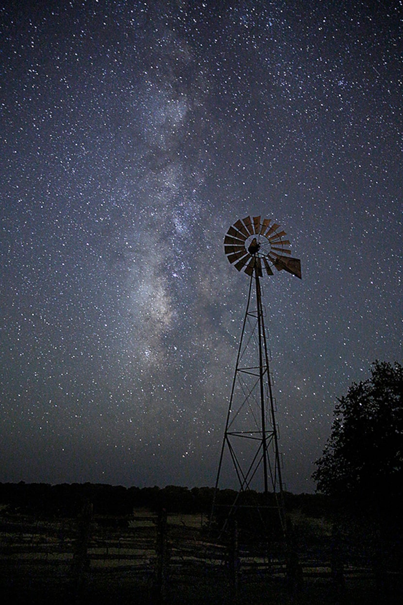  The Milky Way galaxy begins to set behind a wind mill in the Hill Country outside of Mason,...