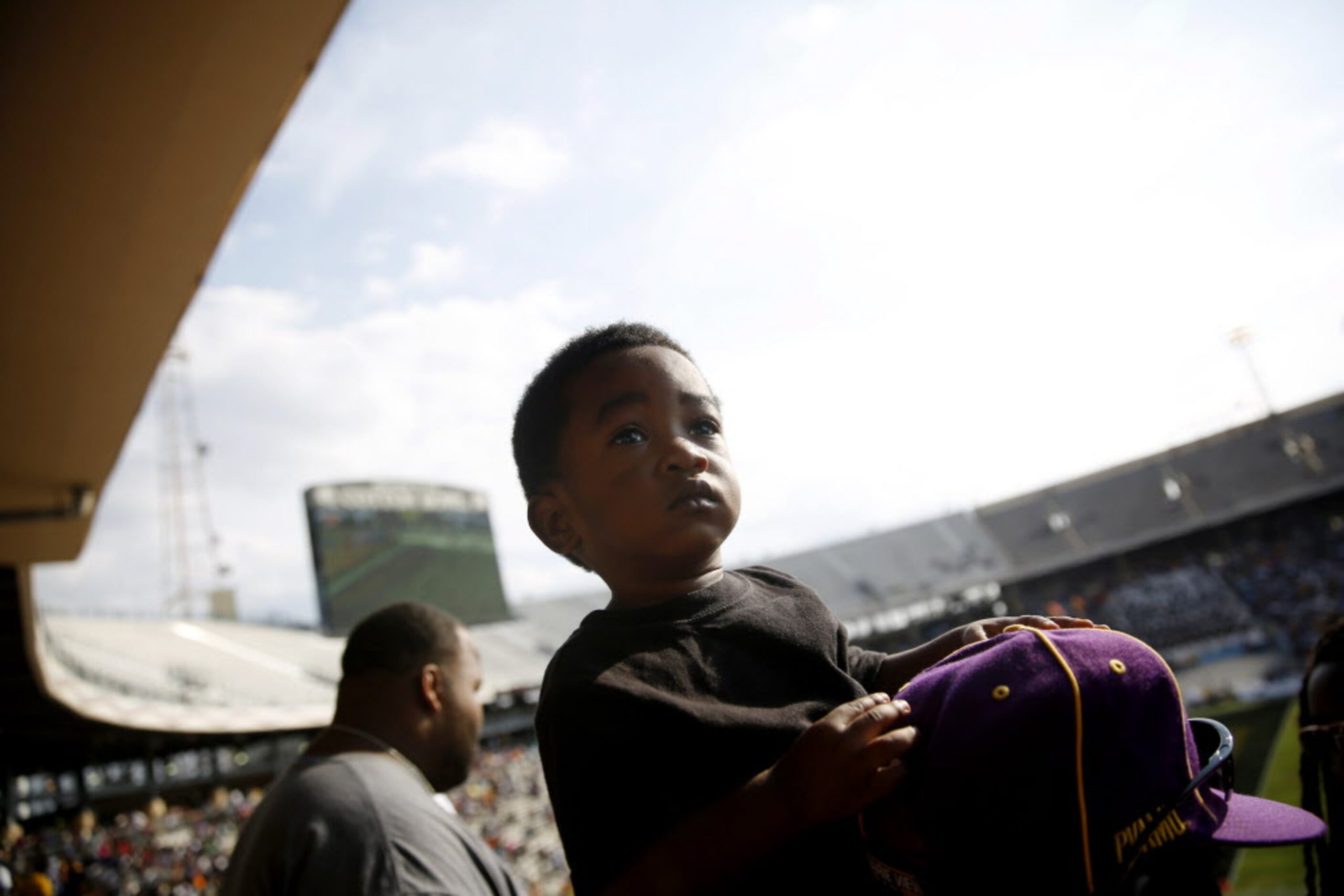 Xavier Curley is perched on his father's shoulders, James Curley, of Fort Worth, while...