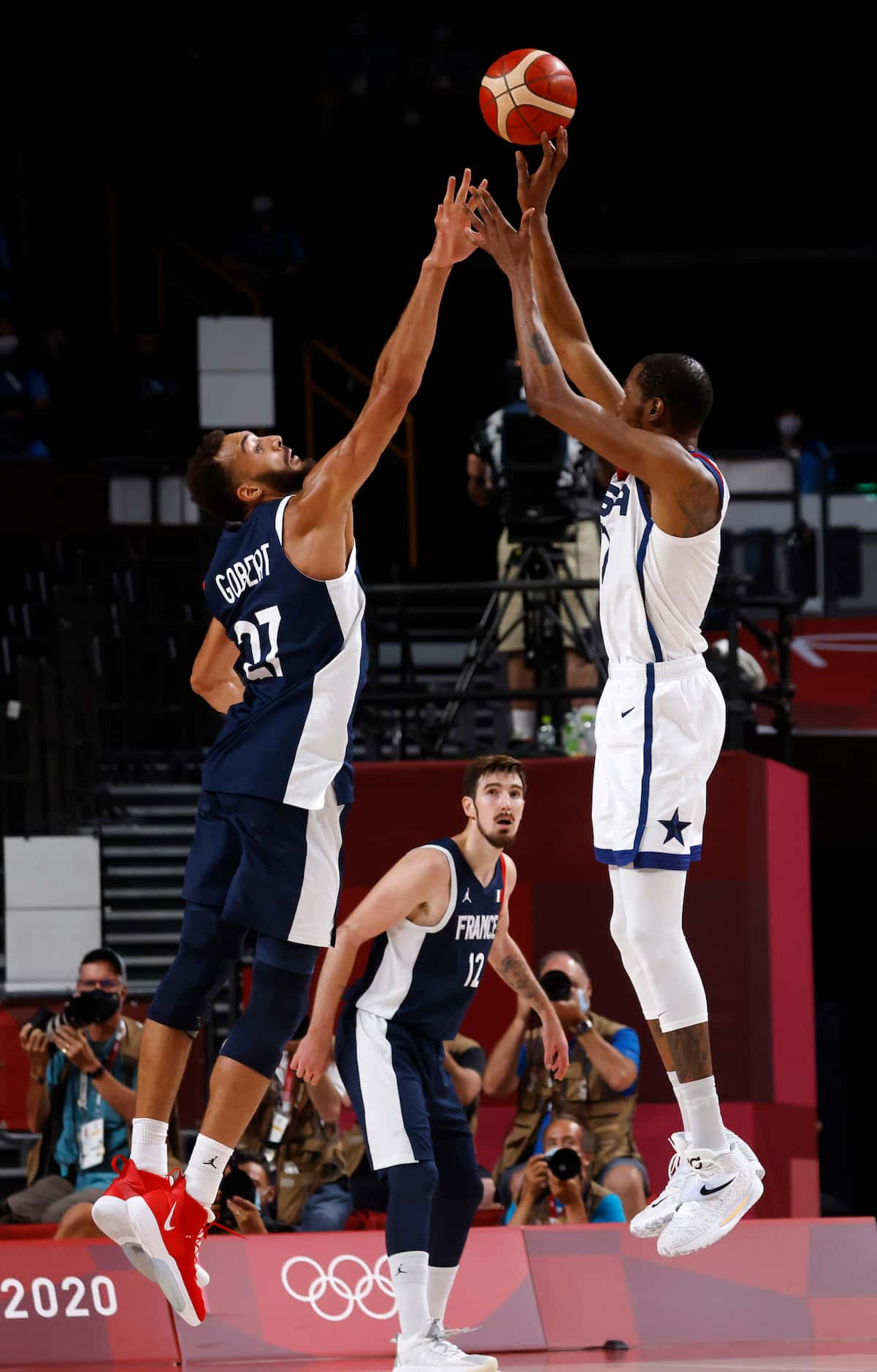 USA’s Kevin Durant (7) shoots and makes a three pointer over France’s Rudy Gobert (27)...