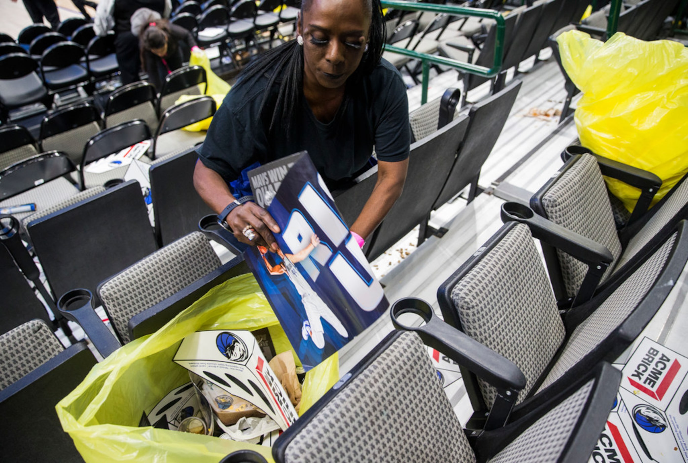 Brenda Brown picks up trash left by fans after the Dallas Mavericks beat the Denver Nuggets...