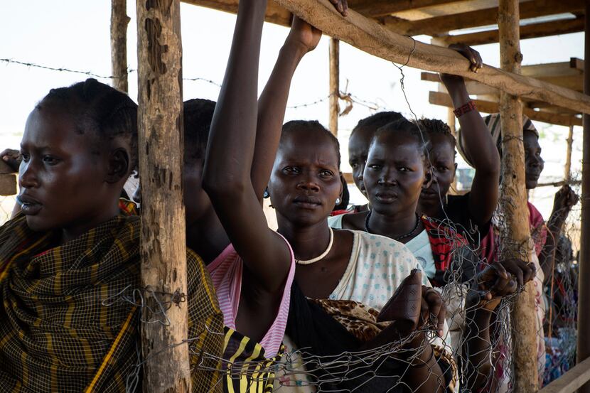 Women wait at a food distribution site in a United Nations camp outside Juba, South Sudan,...