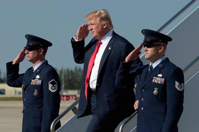 President Donald Trump salutes as he arrives a Palm Beach International Airport in West Palm...