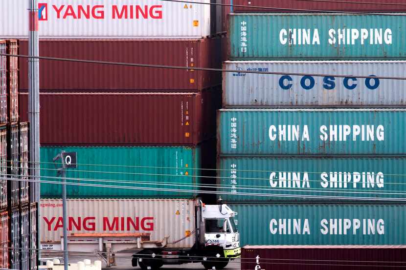 A truck passes by China Shipping containers at the Port of Los Angeles, after new tariffs on...