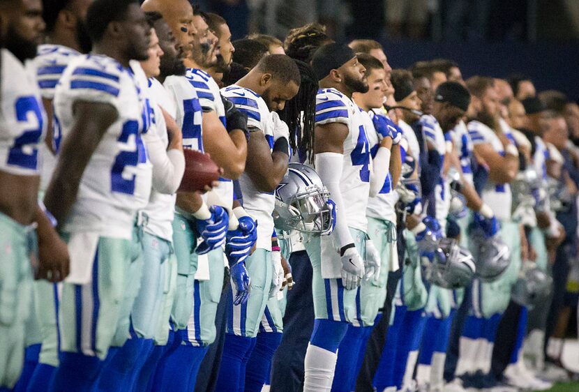 Dallas Cowboys players stand for the national anthem before an NFL football game against the...