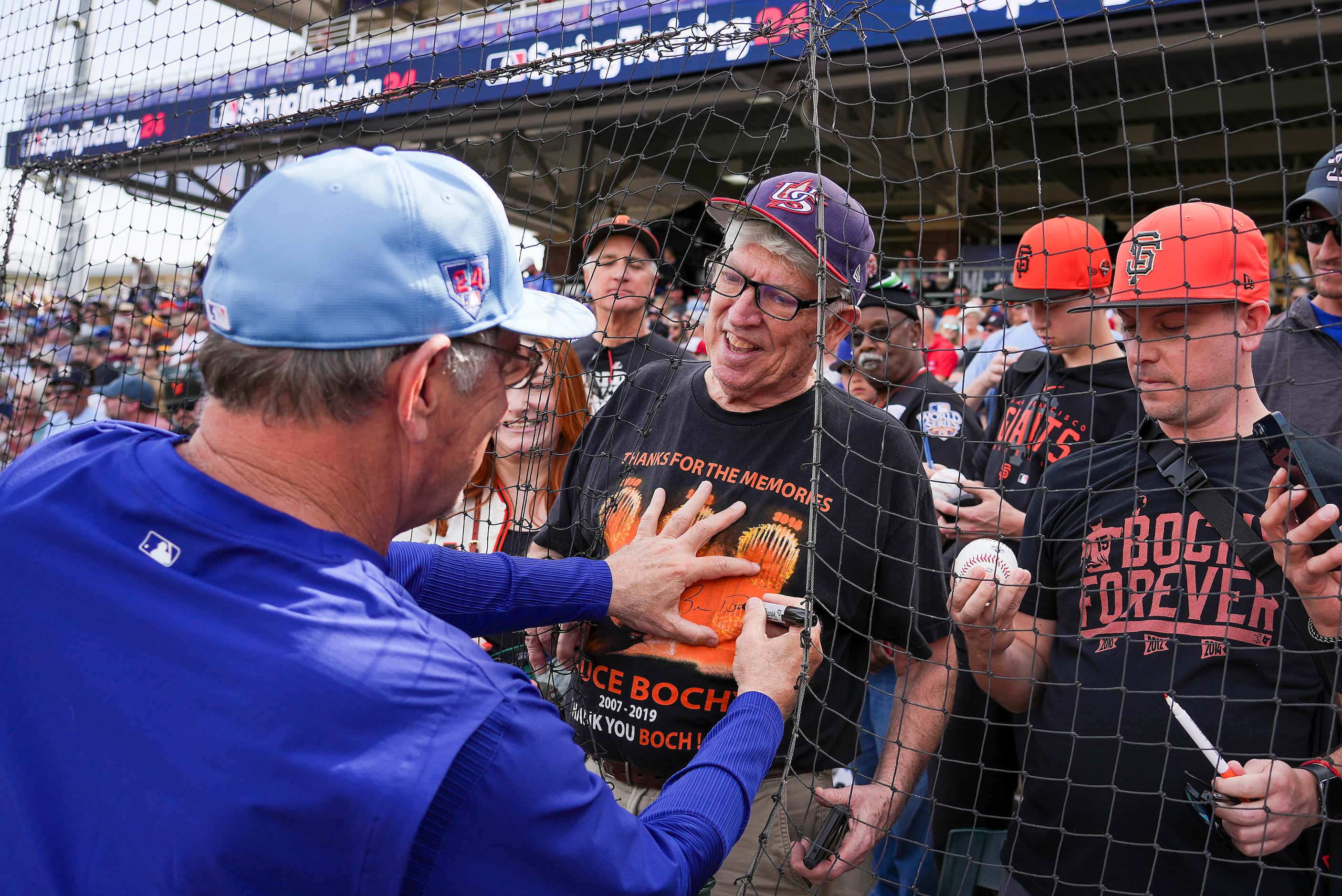 Texas Rangers manager Bruce Bochy autographs a fan’s t-shirt thanking him for his time as...